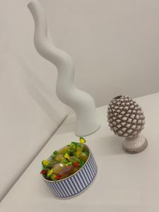two white vases and a bowl on a table at AmaRé House in Bari