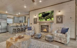 un salon avec cheminée et une cuisine dans l'établissement Friendly Bear Plunge, à Pigeon Forge