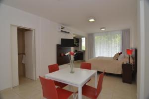 a living room with a white table and red chairs at My Apart in Buenos Aires