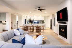 a living room with a couch and a dining room at Luxury Pool Sauna Spa Tennis Court in Mount Martha