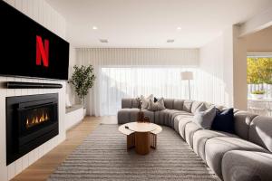 a living room with a couch and a fireplace at Luxury Pool Sauna Spa Tennis Court in Mount Martha