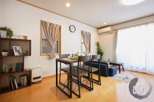 東京にあるUU Houseのテーブルとソファのあるリビングルーム