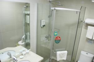 a bathroom with a shower and a sink and a toilet at GreenTree Inn Shandong Laiwu Gangcheng Express Hotel in Laiwu