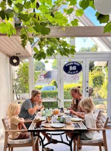 a group of people sitting at a table at Koppes Mølle B&B - naturnær overnatning in Borup