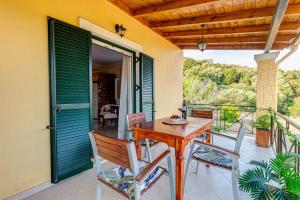 a porch with a wooden table and chairs on a balcony at J and P Nature's Escape in Pouládes