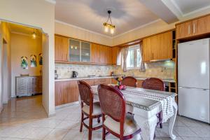 a kitchen with a table and chairs and a refrigerator at J and P Nature's Escape in Pouládes