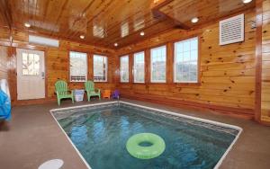 a swimming pool in a wooden house with a room with windows at Splash N Mountain Lookout in Pigeon Forge
