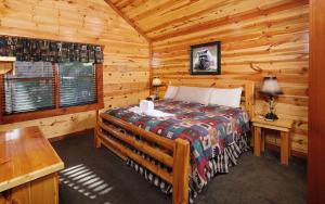 a bedroom with a bed in a log cabin at Splash N Mountain Lookout in Pigeon Forge +42 photos