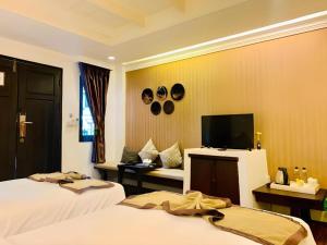 ein Hotelzimmer mit zwei Betten und einem Flachbildfernseher in der Unterkunft B2 Suthep Night Market Premier Resort in Chiang Mai