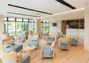 a waiting room with blue chairs and tables at Trat City Hotel in Trat