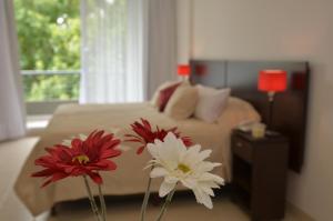 a bedroom with a bed with two red and white flowers at My Apart in Buenos Aires