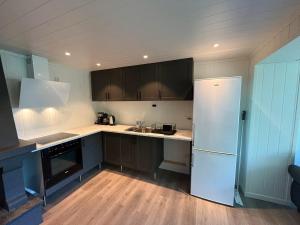 a kitchen with a white refrigerator and wooden floors at The simple appartment in Stryn in Stryn