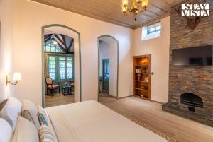 Postel nebo postele na pokoji v ubytování StayVista at The Emily Chalet 7 BR House in Nainital with Bonfire, BBQ