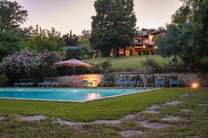 a swimming pool in front of a house at DOLCE COLLINA 10, Emma Villas in Cesena