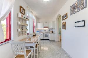 a kitchen with white cabinets and a table and chairs at U bissu in Marittima +18 photos
