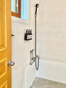 a shower with a hose in a bathroom at Gangneung Sia Stay in Gangneung
