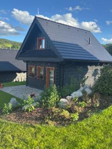 a small house with a garden in front of it at tradičná Čičmanská drevenica in Čičmany