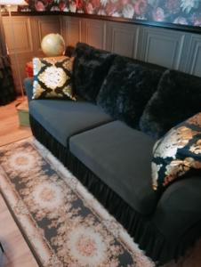 a blue couch in a living room with a rug at SUITE THE BLESSING "Where Heaven Touches Earth" in Bruges