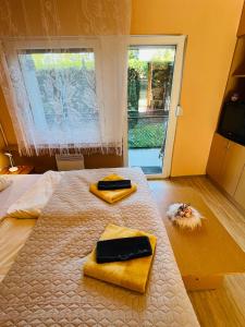 a bedroom with a bed with two towels on it at Balcsitthon Ezüstpart in Siófok