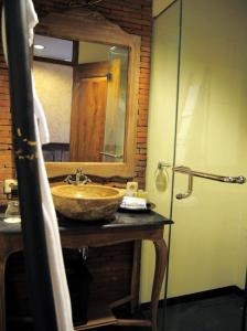 a bathroom with a sink and a mirror at Omah Sinten Heritage Hotel & Resto in Solo