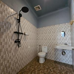 a bathroom with a camera on the wall and a toilet at Ridho Malik Hotel in Bumbang +30 photos