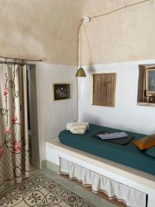 a bedroom with a bed with a blue bedspread at Casettina Matilda in Ostuni +25 photos