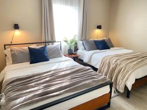 two beds sitting in a room with a window at Cozy Home in National City 15 min from San Diego in National City