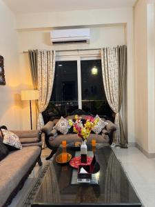 uma sala de estar com um sofá e uma mesa em French Vibes- Luxury apartment, flat, high rise in Gurgaon, Delhi, NCR em Gurgaon