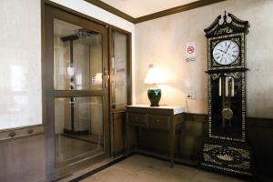 un reloj en la pared en una habitación en Phawana Sweet Hotel, en Bangkok