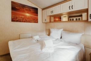 a white bed with two towels on top of it at Villa Hexenholz in Thale