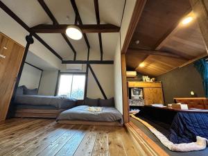 Un dormitorio con 2 camas y un escritorio en una habitación. en 古民家宿 AKIYA nehemiah 淡路島, en Awaji 27 fotos más
