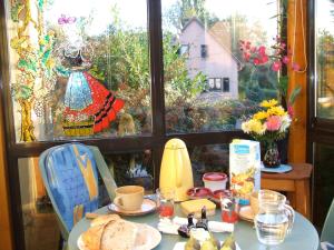 einen Tisch mit einem Teller Brot und einem Fenster in der Unterkunft les lilas in Ammerschwihr