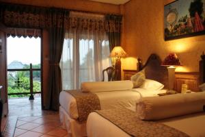 a hotel room with two beds and a balcony at Omah Sinten Heritage Hotel & Resto in Solo +41 photos