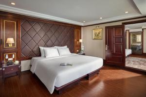 Un dormitorio con una gran cama blanca en una habitación. en Verdure Lotus Classic Cruise on Lan Ha Bay, en Ha Long