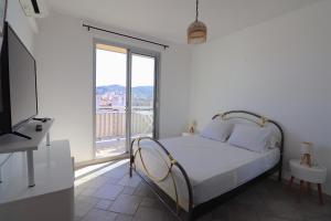 阿雅克修Spacieux Appartement Vue Mer et Montagne en dernier étage avec Terrasse - Parking et Wifi的一间带床和大窗户的白色卧室