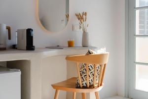 a wooden chair sitting next to a counter with a mirror at Naxos Tower in Naxos Chora