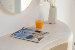 a glass of orange juice and a magazine on a table at Naxos Tower in Naxos Chora