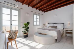 a white bedroom with a bed and a table at Naxos Tower in Naxos Chora