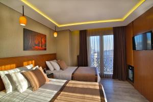 a hotel room with two beds and a television at Corner Hotel Laleli in Istanbul