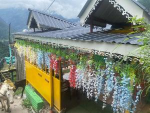 um edifício com um ramo de flores pendurado nele em Om parvati em Kasol
