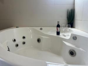 a white bath tub with a bottle of wine and glasses at Genesis Land Desert hospitality in Kfar Adumim +46 photos