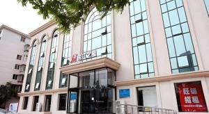 a large building with a sign on the front of it at Jinjiang Inn Hotel Tianjin Xinkai Road Branch in Tianjin