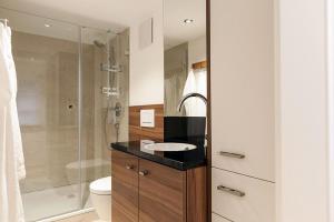 une salle de bain avec un lavabo et une douche dans l'établissement Maximilian Apartments Lindau, à Lindau 46 autres photos