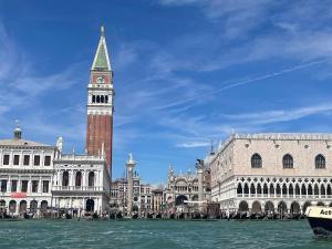 ein Gebäude mit einem Turm, auf dem eine Uhr angebracht ist in der Unterkunft Ca' ai Sospiri in Venedig + 28 Fotos