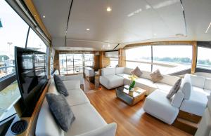 ホーチミン・シティにあるPremium Saigon Yacht Princess 62 - Managed by Vietyacht Clubの白い家具が置かれたボートのリビングルーム