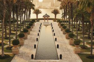 迪拜One&Only Royal Mirage Resort Dubai的公园里一条有树木和水的步道
