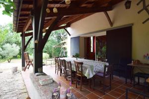 Un comedor con mesa y sillas en un patio. en Gîte La Chênaie, maison ancienne pour 13 personnes- Clévacances 3 clés, en Castella
