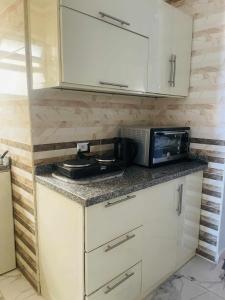 a kitchen with a counter top with a microwave and a counter sidx sidx at Porto marina Panoramica sea view in front marina 2 in El Alamein