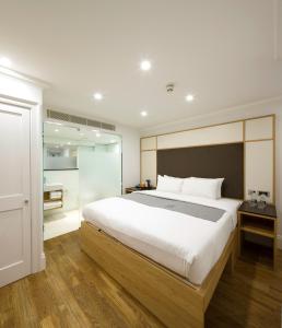 a bedroom with a large bed and a bathroom at The Z Hotel Gloucester Place in London