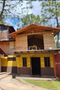 a yellow house with a wooden roof at Cabañas Ángela 3 in Mazamitla